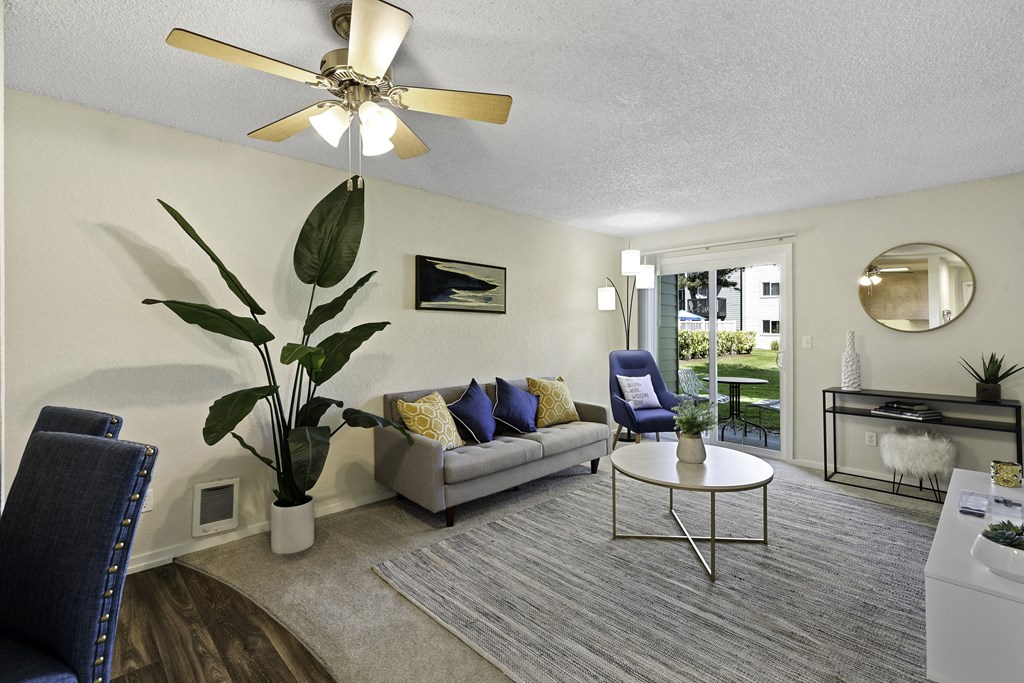 a living room with a couch coffee table and a ceiling fan at Pacific Park Apartment Homes, Edmonds, Washington 98026