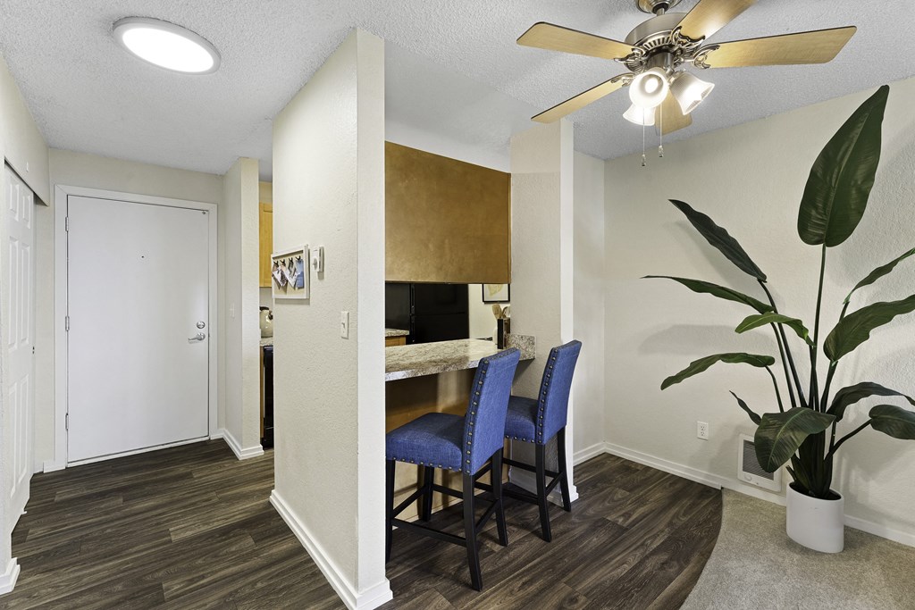 a dining area with a table and chairs and a ceiling fan at Pacific Park Apartment Homes, Edmonds