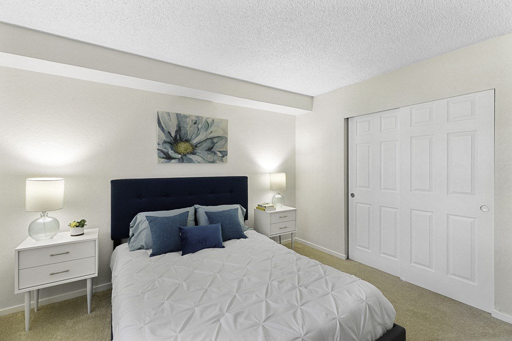 a bedroom with a bed and two night stands at Pacific Park Apartment Homes, Edmonds