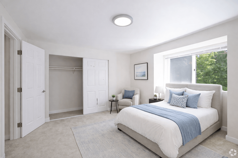 A bedroom with a large bed and a window.