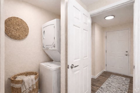 A white laundry machine sits next to a basket in a small room.