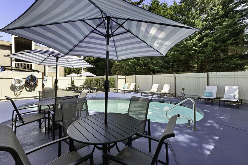 Unique Swimming Pool with Table, Chairs, and Umbrella Unique Swimming Pool with Table, Chairs, and Umbrella for Relaxing in the Shade at Park 210 Apartment Homes, Washington