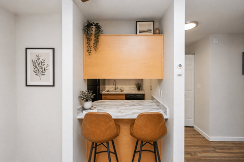 A kitchen with a table and two chairs.