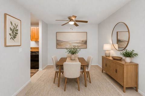 A dining room with a wooden table and chairs.