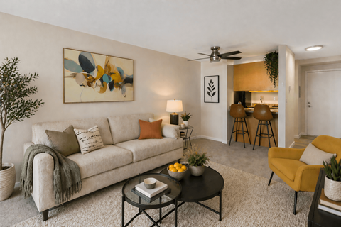 A living room with a couch, a chair, a table, and a painting on the wall.