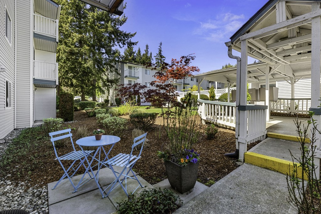 a patio with two chairs and a table in front of a building