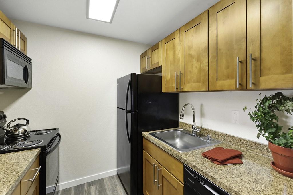 a kitchen with wooden cabinets and black appliances