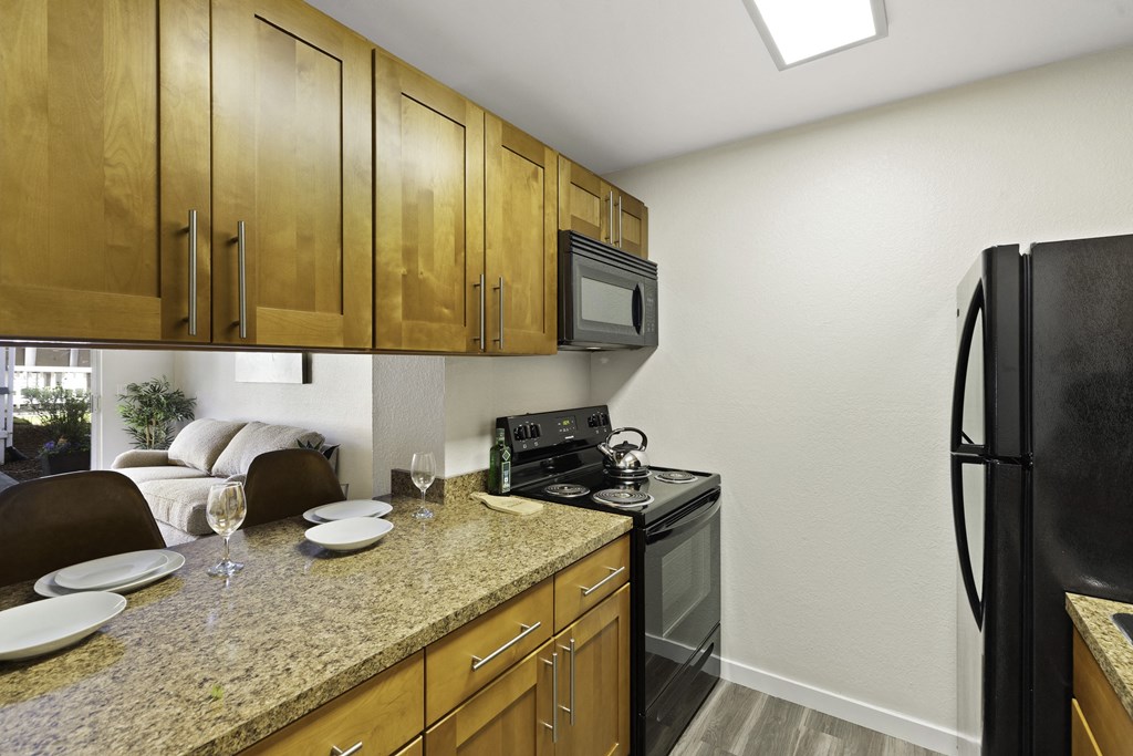 a kitchen with wooden cabinets and a granite counter top