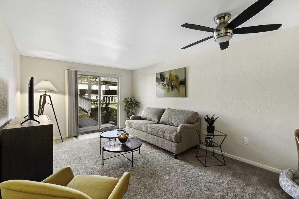 a living room with a couch coffee table and a ceiling fan