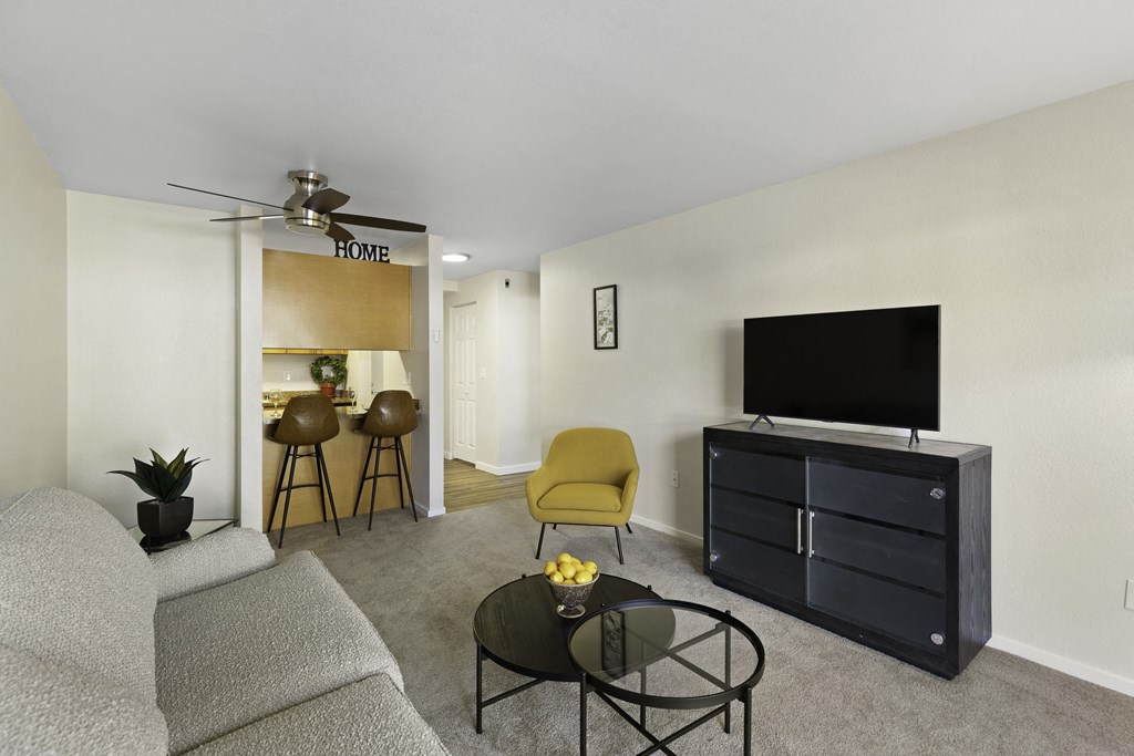 a living room with a couch coffee table and a tv on top of a dresser