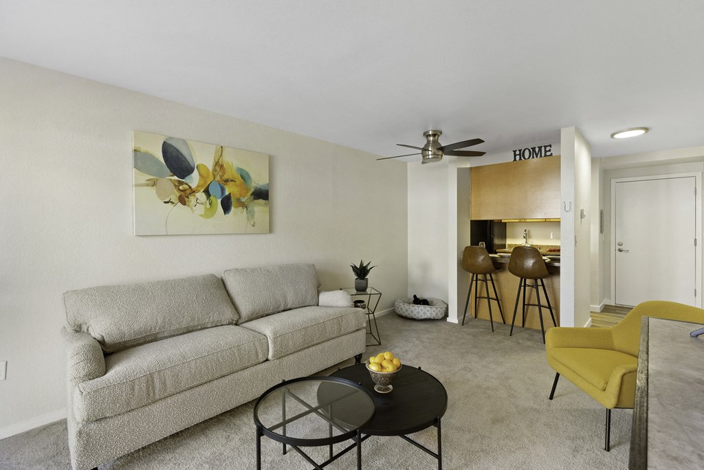 a living room with a couch a table and a ceiling fan