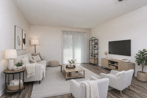 A living room with a white couch, a wooden coffee table, and a flat-screen TV mounted on the wall.