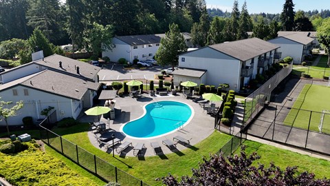 A pool surrounded by a fence and trees.