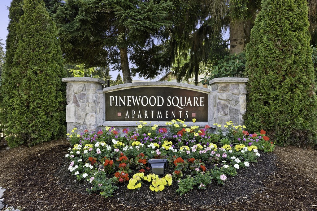 Stone Welcome Sign to Pinewood Square Apartment Homes with Flower Bed Below Stone Welcome Sign to Pinewood Square Apartment Homes with Flower Bed Below at Pinewood Square Apartment Homes, WA 98087