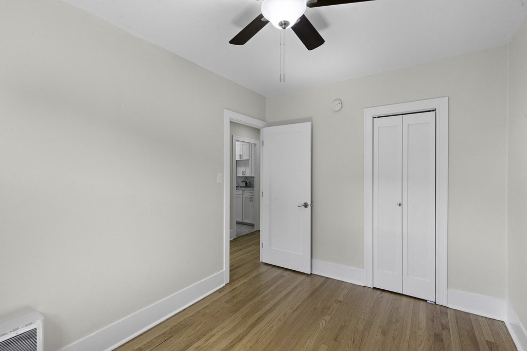 a bedroom with hardwood floors and a ceiling fan at Stockbridge Apartment Homes, Washington