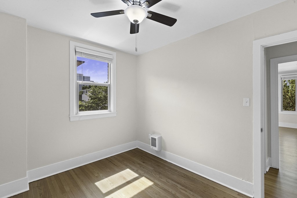 a bedroom with a ceiling fan and hardwood floors at Stockbridge Apartment Homes, Washington, 98101