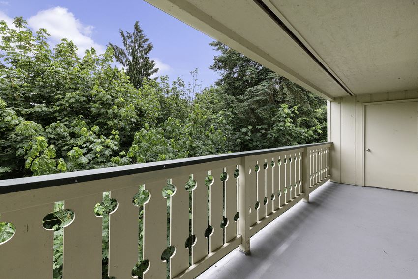 a balcony with trees in the background a balcony with trees in the background at Swiss Gables Apartment Homes, Kent, WA - Photo Gallery