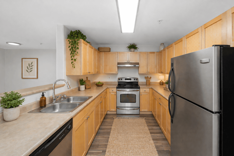 A kitchen with wooden cabinets and a black refrigerator.