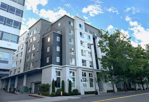 A modern multi-story building with a mix of white and dark grey balconies.