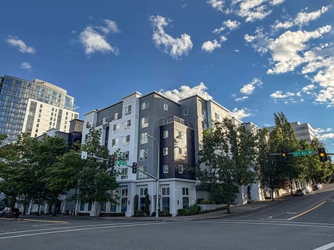 A street view of a white building with a green traffic light.