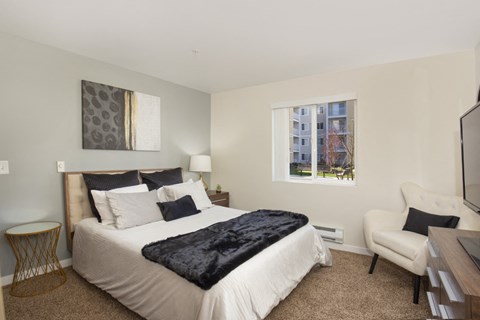 a bedroom with a bed and a desk and a window