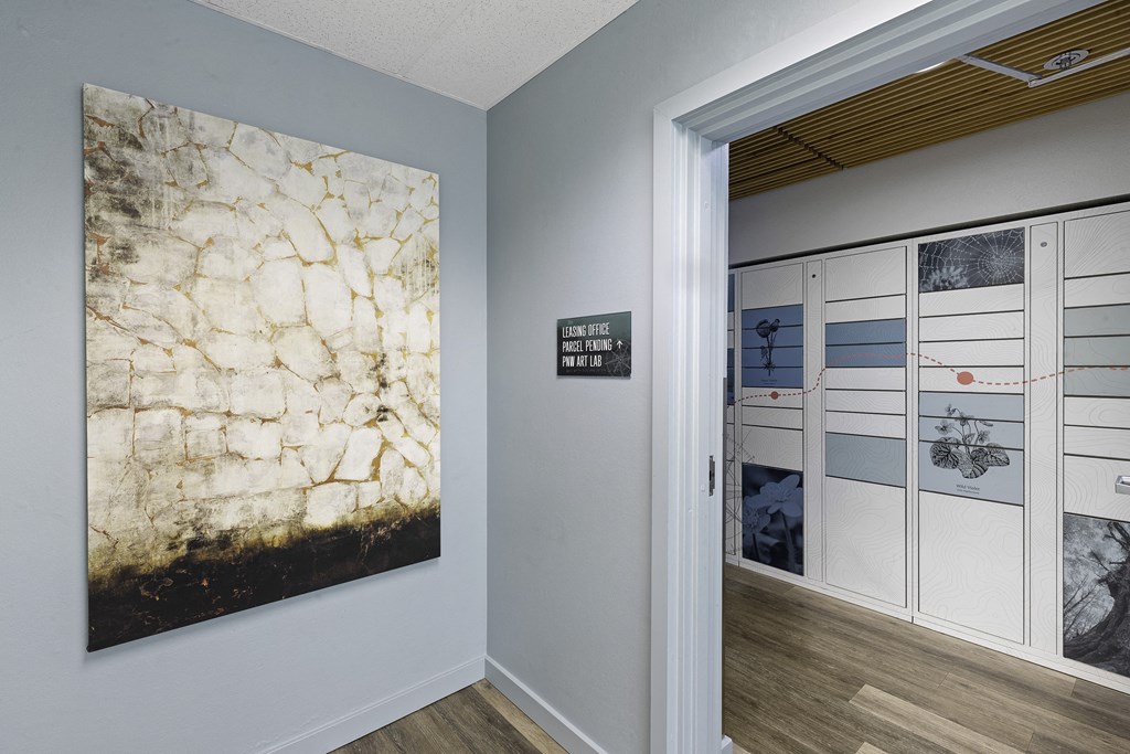 Hallway with a Painting that Leads to the Package Receiving Lockers at Excalibur Apartment Homes, WA 98004