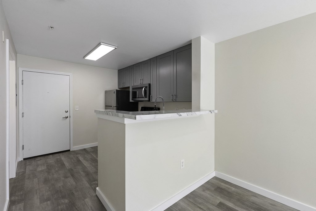 Kitchen View with a Counter Top Breakfast Bar at Excalibur Apartment Homes, WA 98004