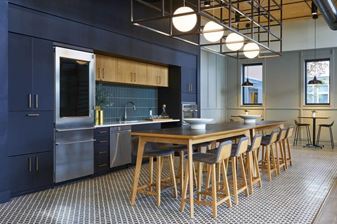 A kitchen with a long wooden table and bar stools.