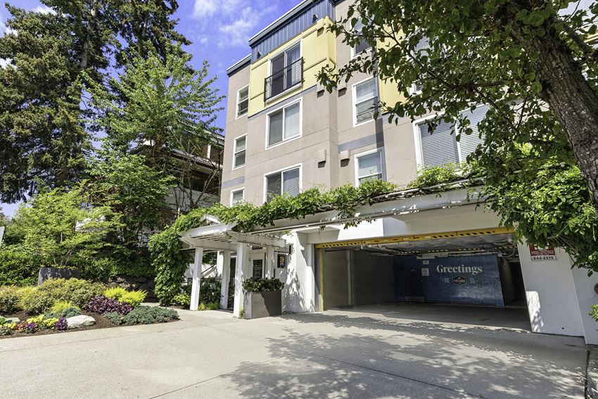 a large apartment building with a parking lot in front of it a large apartment building with a parking lot in front of it at Sir Gallahad Apartment Homes, Bellevue, 98004 - Photo Gallery