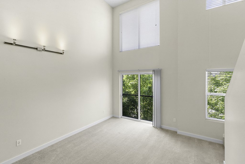 Loft Style Apartment with Massive Open Living Room Space, Wide Oversized Windows with Views of Greenery, Sliding Glass Door, and Lofty Ceilings at Sir Gallahad Apartment Homes, Bellevue