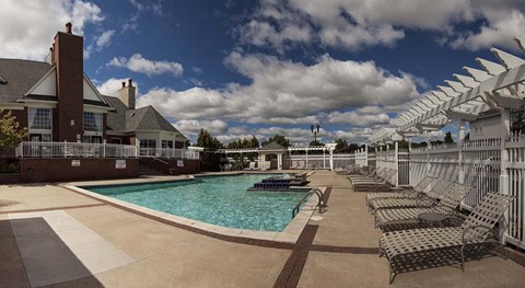 Outdoor swimming pool with lounge chairs and pergola at Brandywine Apartments, West Bloomfield, MI
