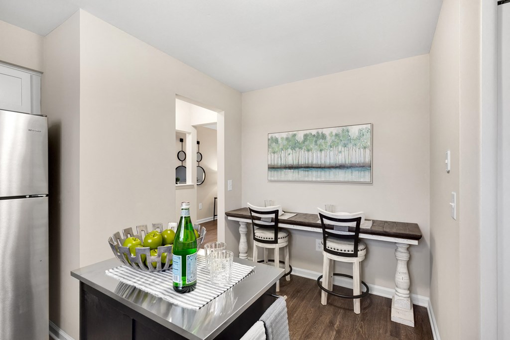 a dining area with a table and chairs and a kitchen in the background  at Northridge, Rochester Hills, Michigan