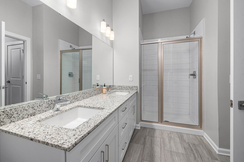 a bathroom with a large mirror and a shower with a glass door  at Griffin Weston, North Carolina