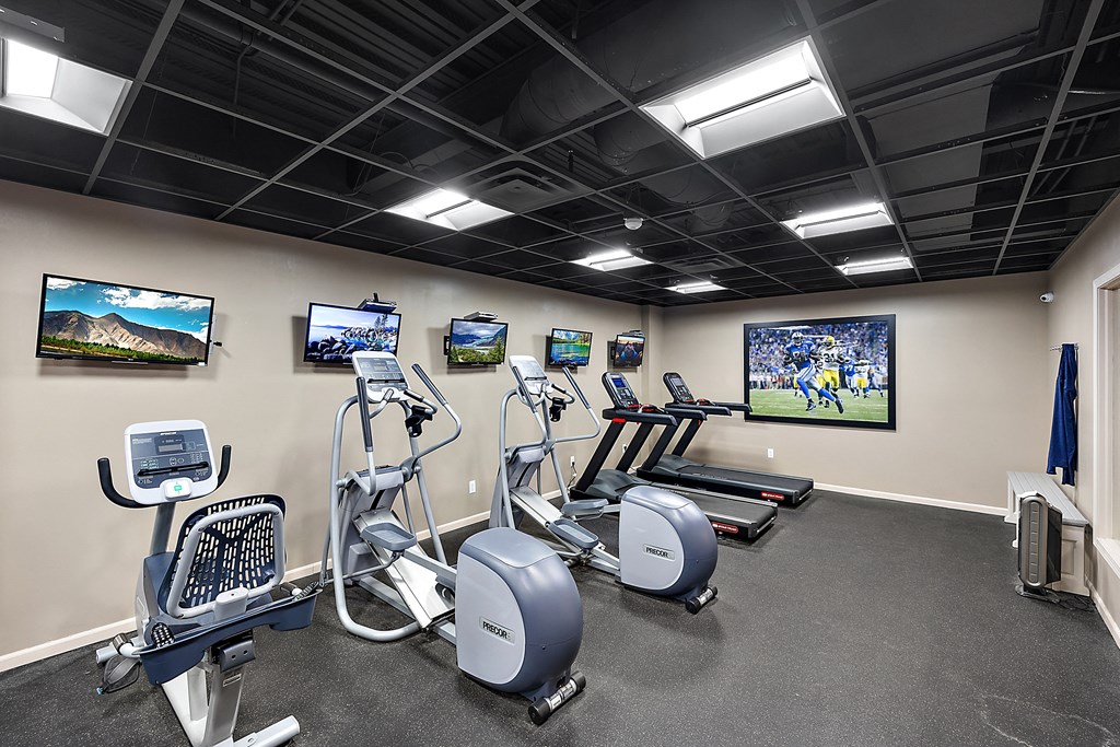 A gym with a row of exercise bikes and treadmills at MainCentre, Northville