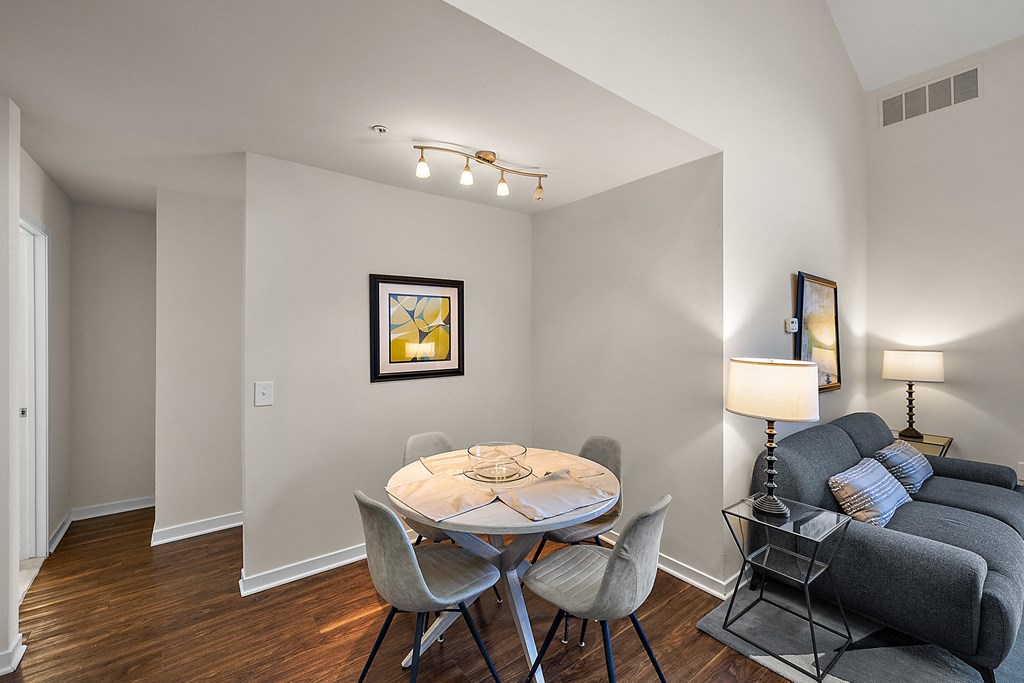 A living room with a grey couch, a white table and a painting on the wall at MainCentre, Northville