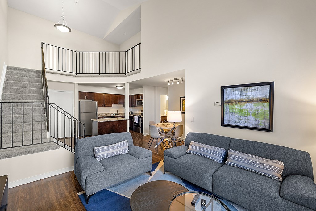 A living room with a grey couch and a painting on the wall at MainCentre, Northville