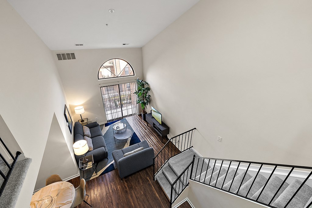 A living room with a couch, a chair, a coffee table, and a staircase at MainCentre, Northville