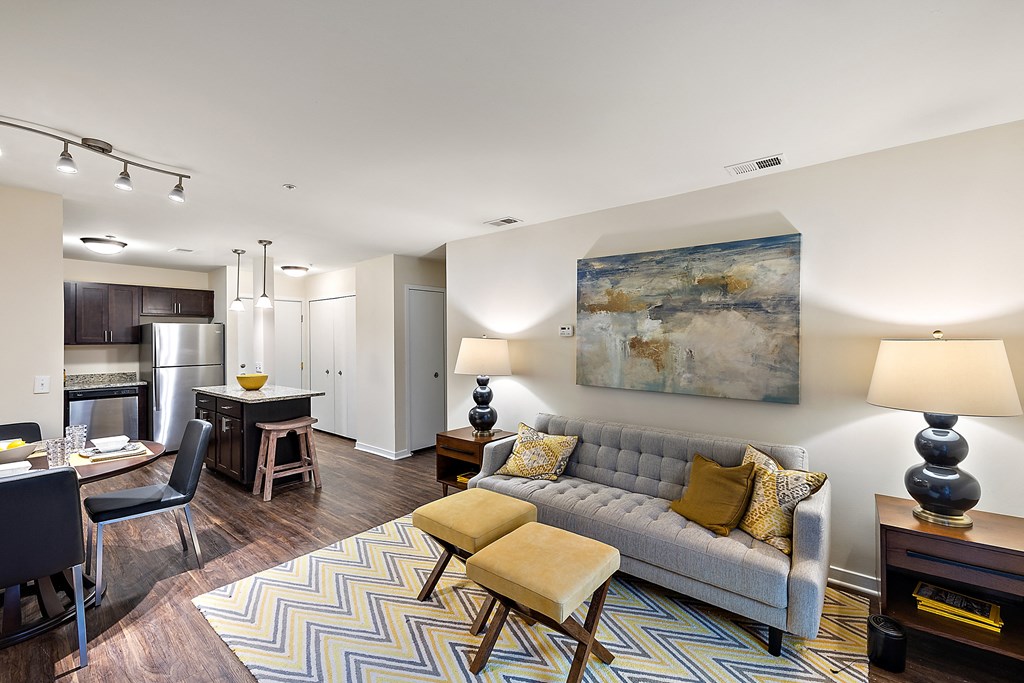 A living room with a grey couch and a painting on the wall at MainCentre, Northville