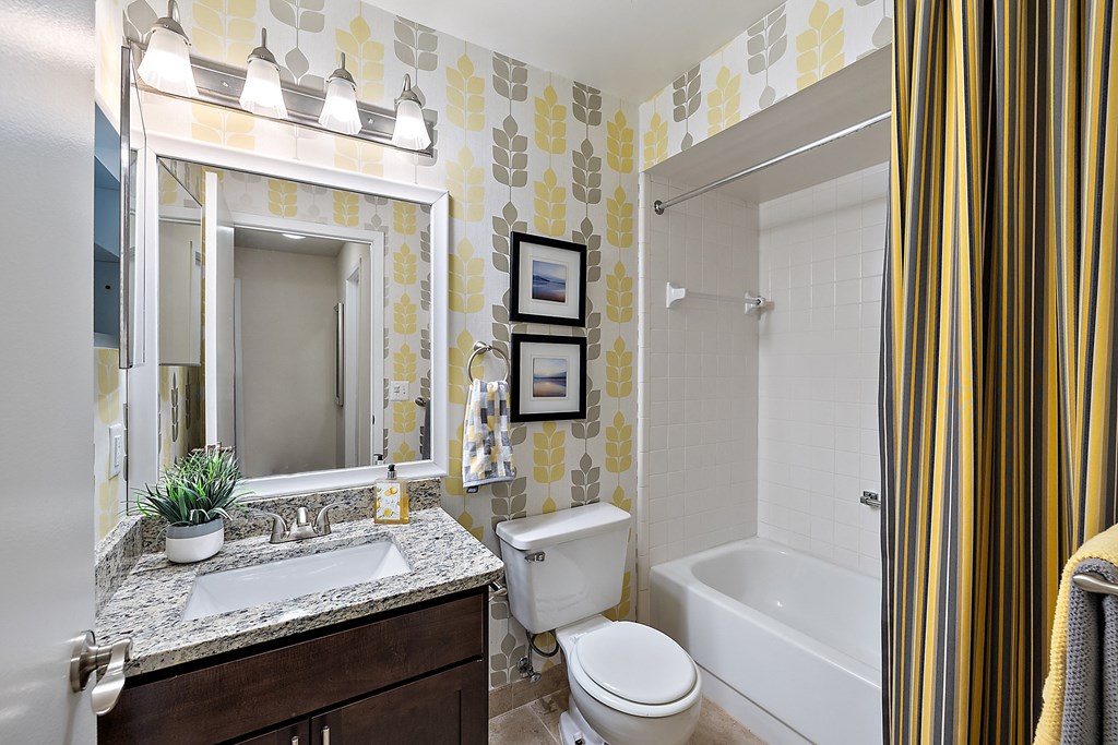A bathroom with a yellow and white patterned wallpaper at MainCentre, Northville