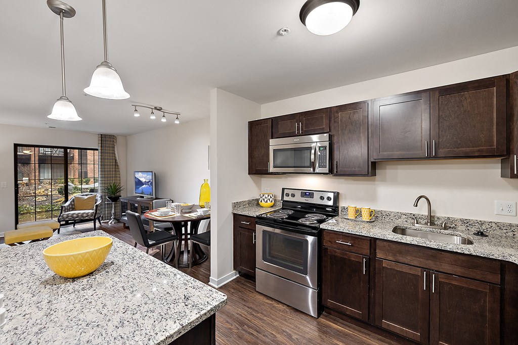 A modern kitchen with granite countertops and stainless steel appliances at MainCentre, Northville