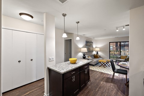 A kitchen with dark wood cabinets and a granite countertop.