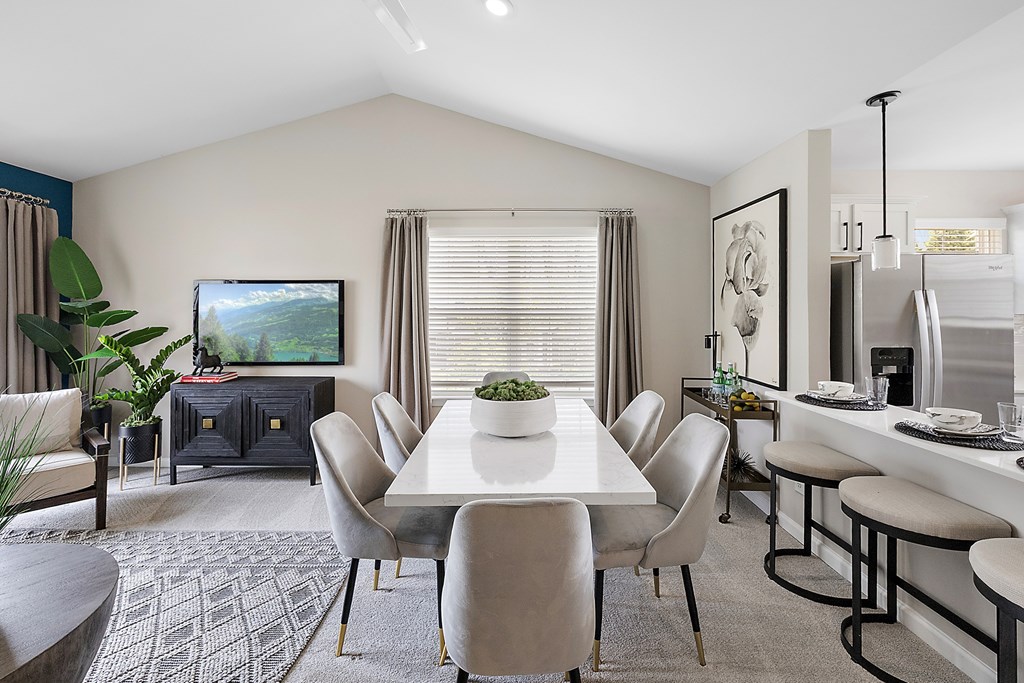 A modern dining room with a large table and chairs.