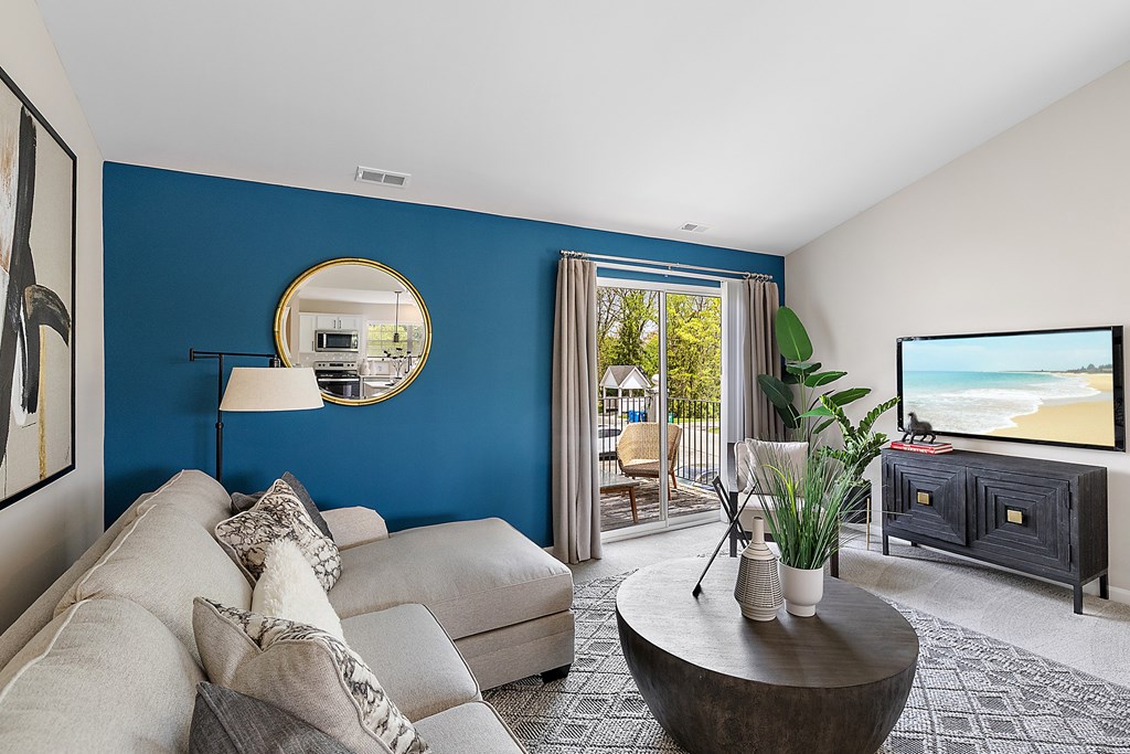 A living room with a grey couch and a round coffee table.