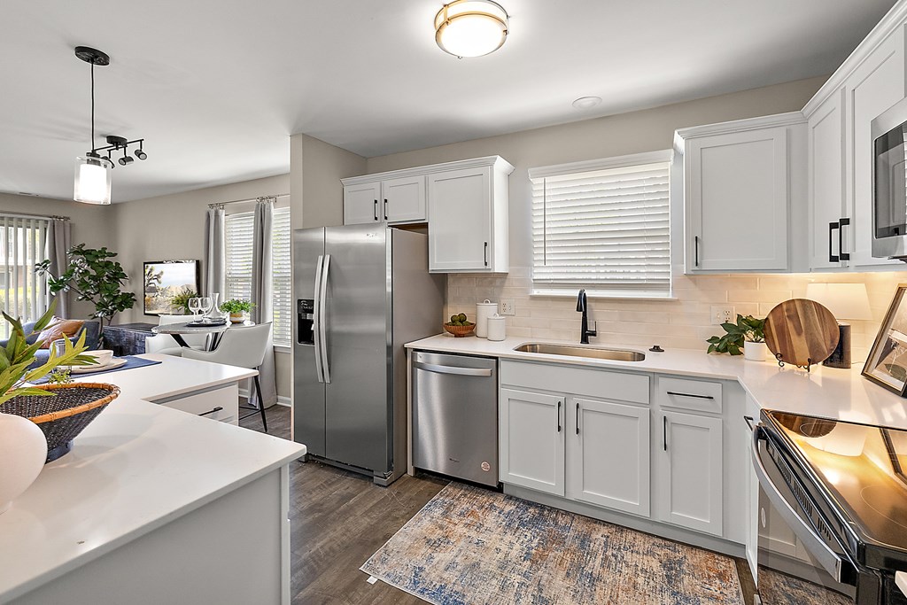A modern kitchen with white cabinets and stainless steel appliances.