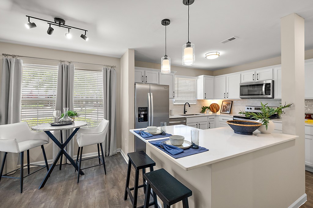 A kitchen with a table and chairs by a window.