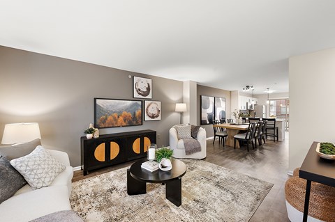 A living room with a grey couch, a coffee table, and a painting on the wall.
