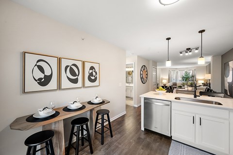 A kitchen with a white counter and black stools.