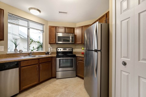 a kitchen with stainless steel appliances and wooden cabinets
