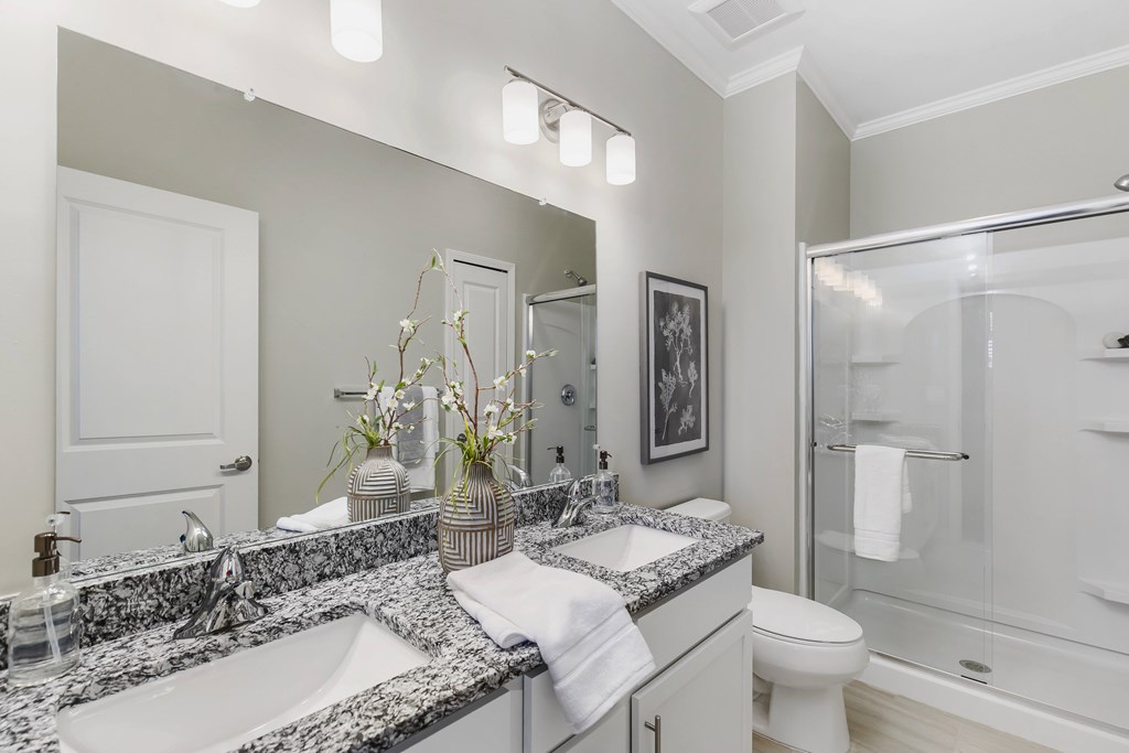 A bathroom with a marble countertop and a toilet at Park West, Canton, 48187