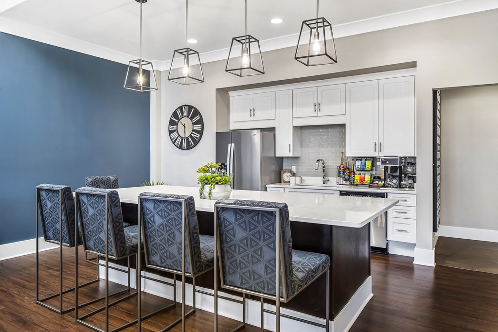 A kitchen with a bar area and chairs.